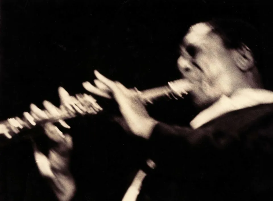 Stylized black and white photo of John Coltrane in performance